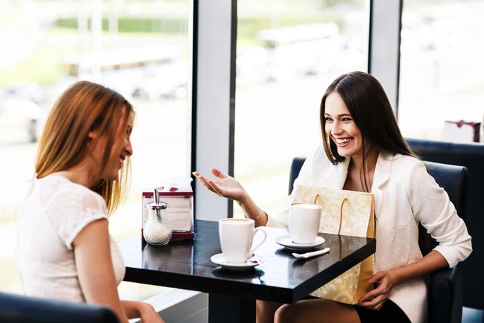 two friends catching up and smiling in a diner booth