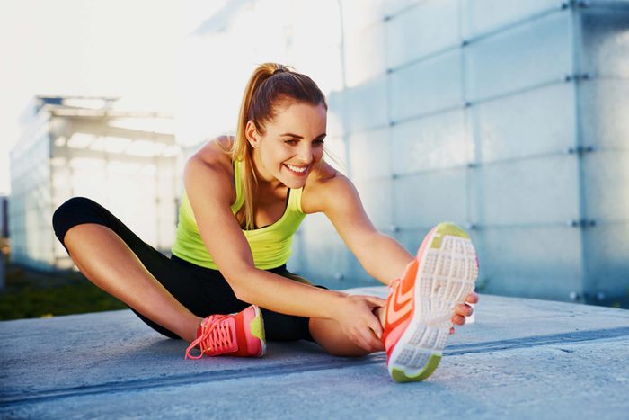 woman in workout attire stretching outdoors