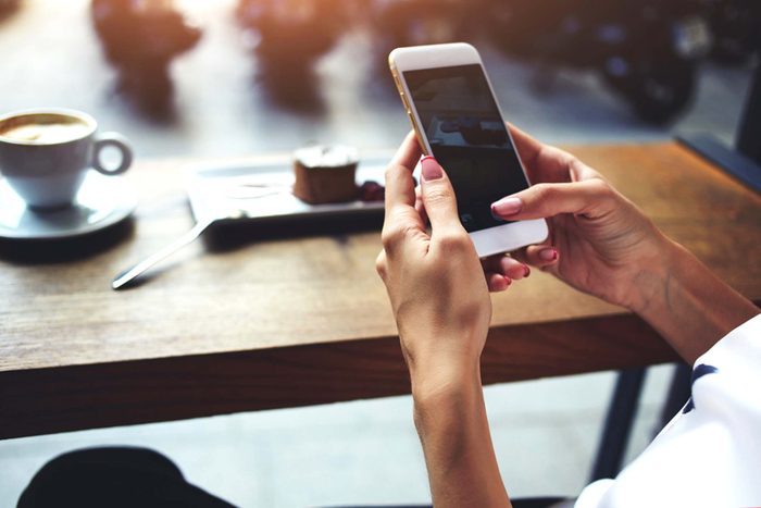 hands holding a smartphone at a table at a coffeeshop