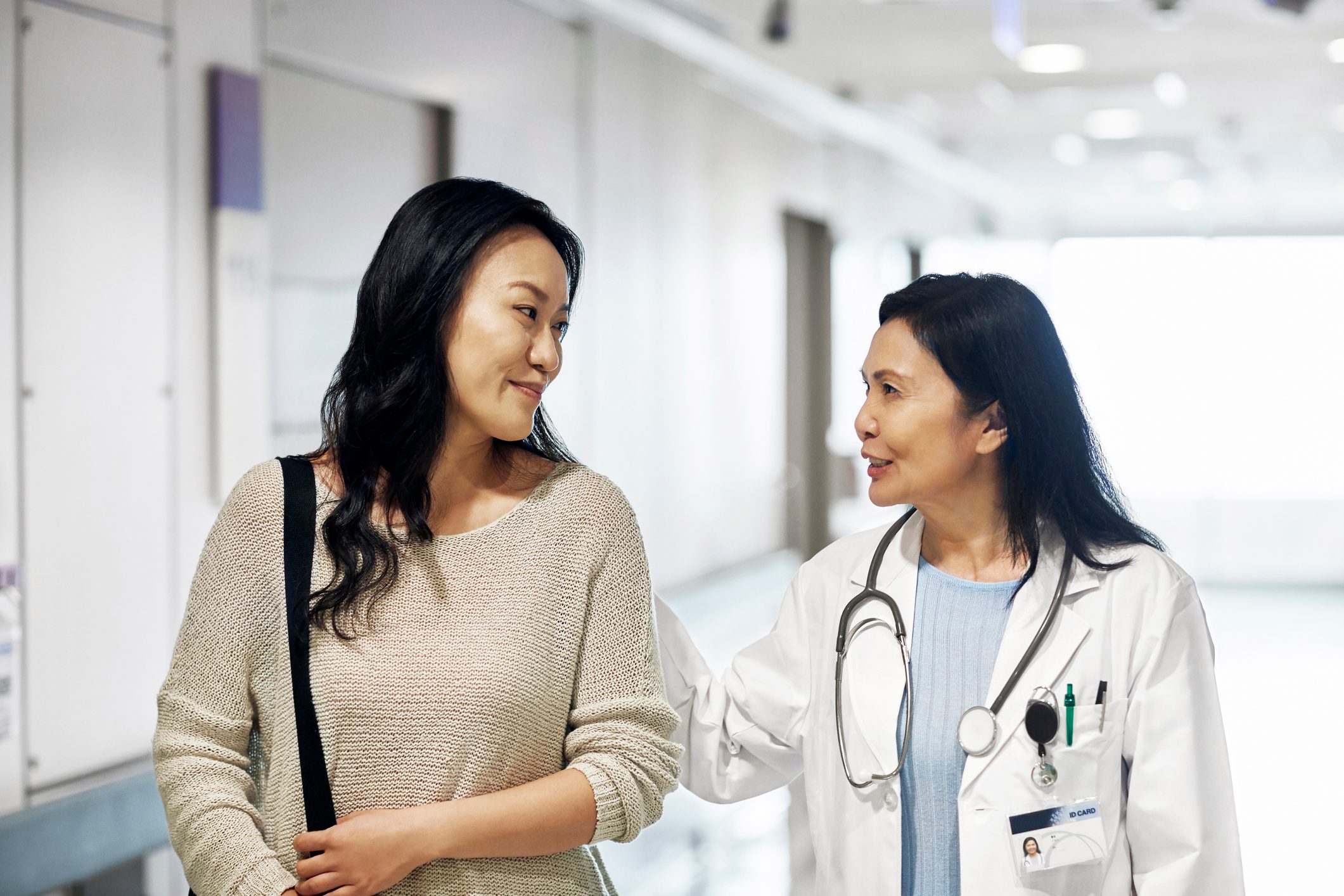 young woman talking with doctor while walking