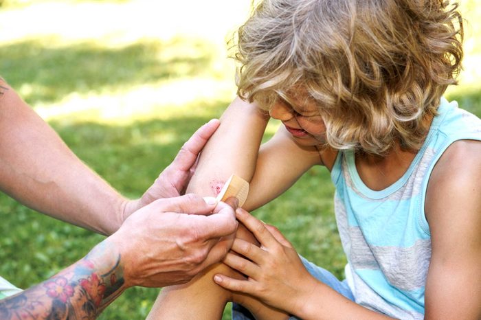 Adult helping clean up a child's scraped elbow
