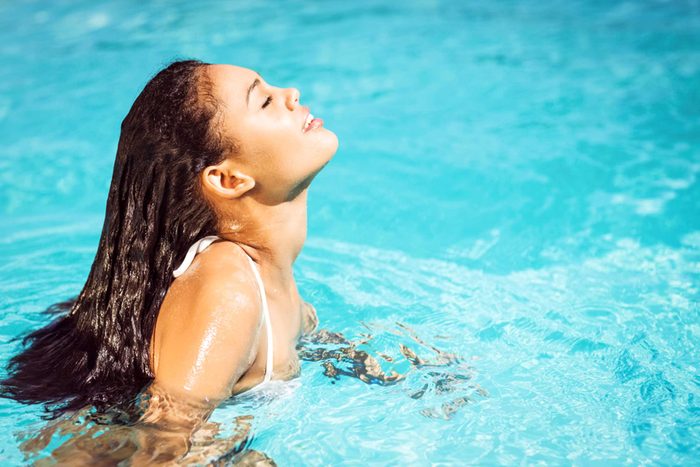 woman with face to the sun, in the pool