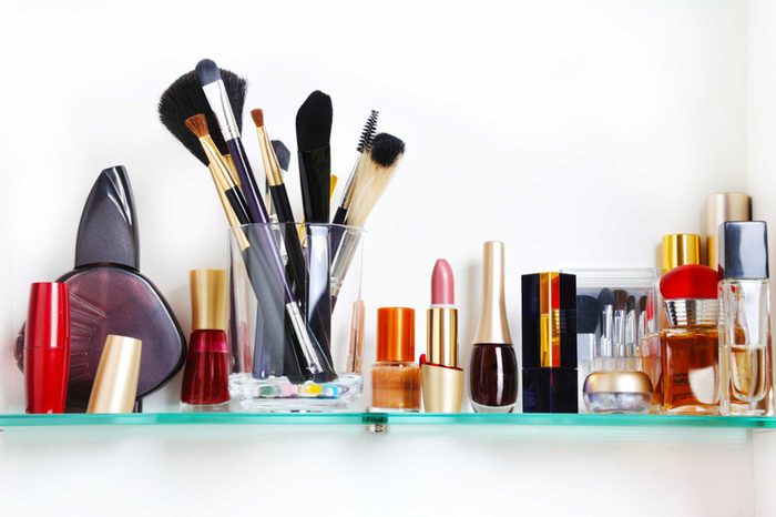 Row of makeup in the bathroom medicine cabinet.