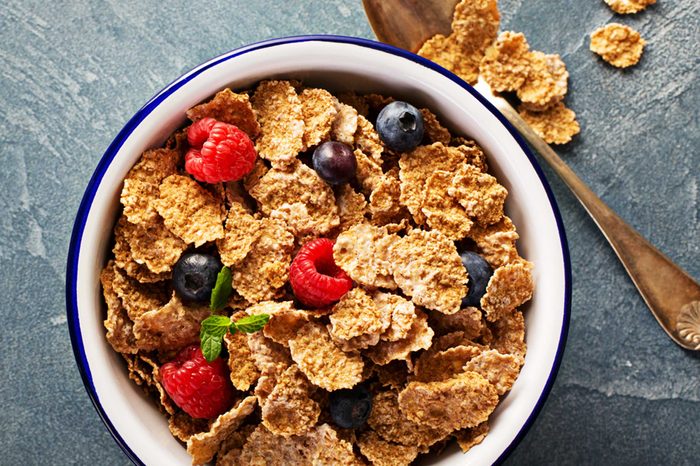 bowl of wheat cereal flakes with blueberries and raspberries