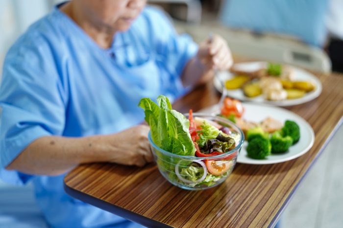 Asian senior or elderly old lady woman patient eating breakfast healthy food with hope and happy while sitting and hungry on bed in hospital.