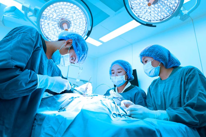 surgeons working on the abdomen of a patient