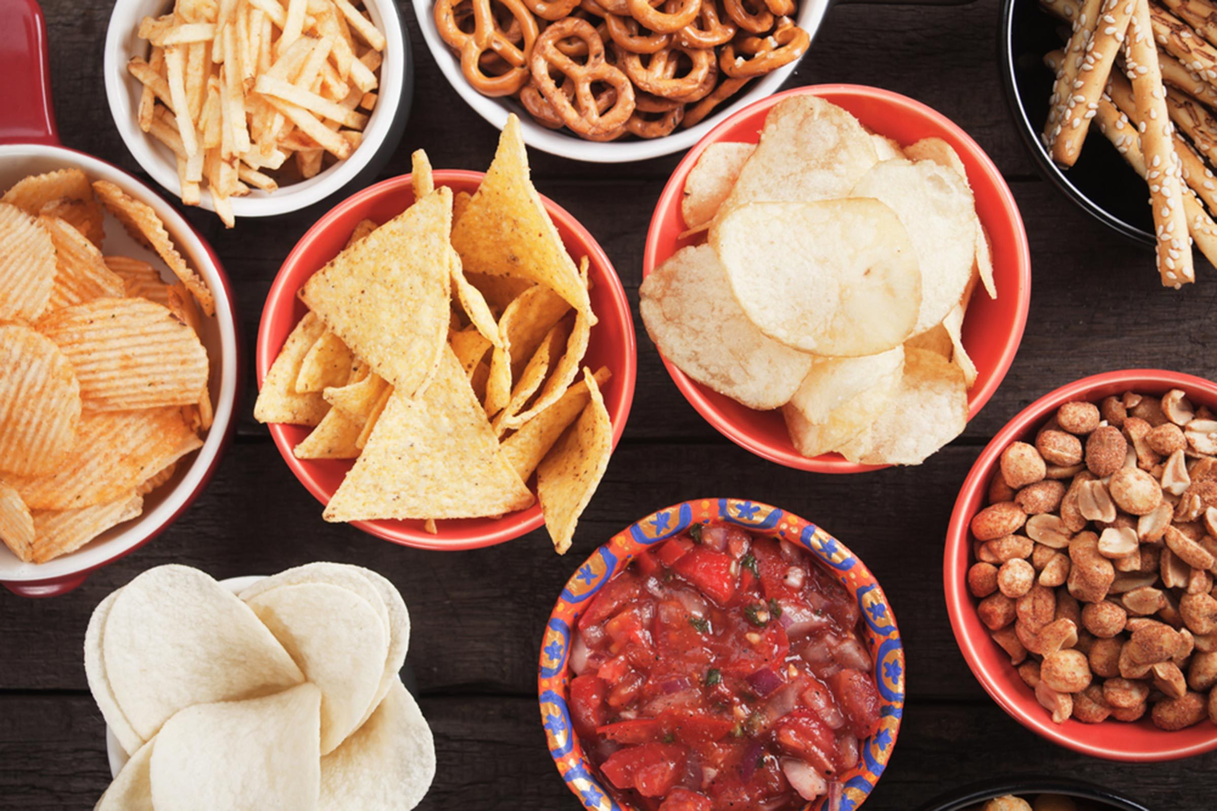 Pretzels, popcorn and potato chips in snack bowls