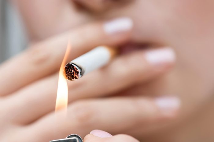 woman lighting a cigartette