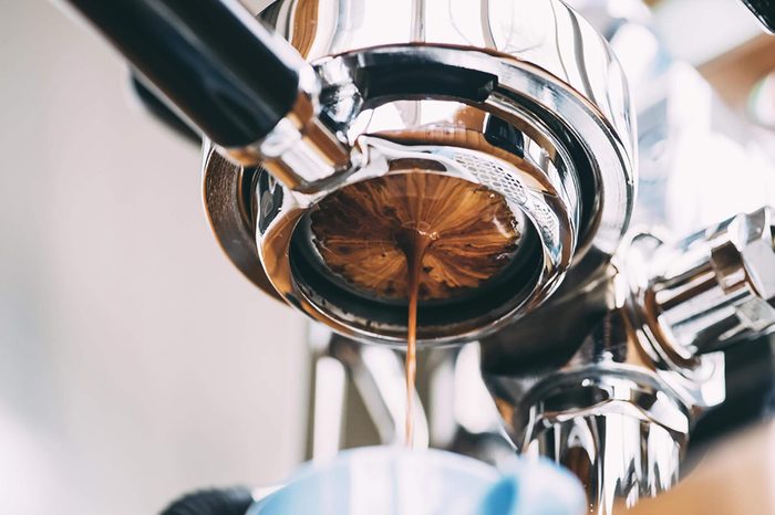 An espresso cup and espresso machine.