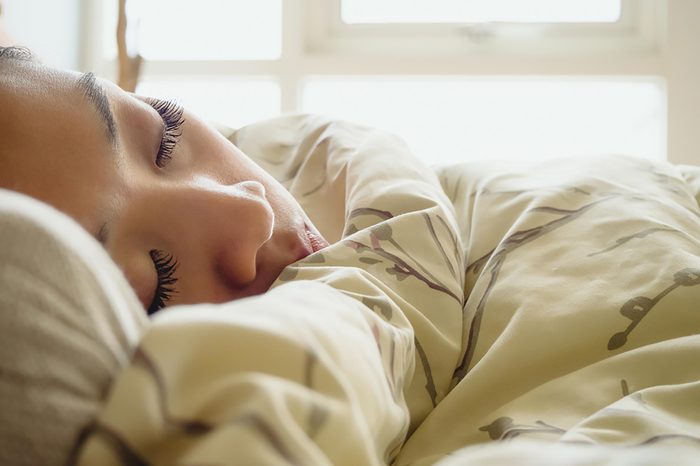 Woman sleeping peacefully in a bed.
