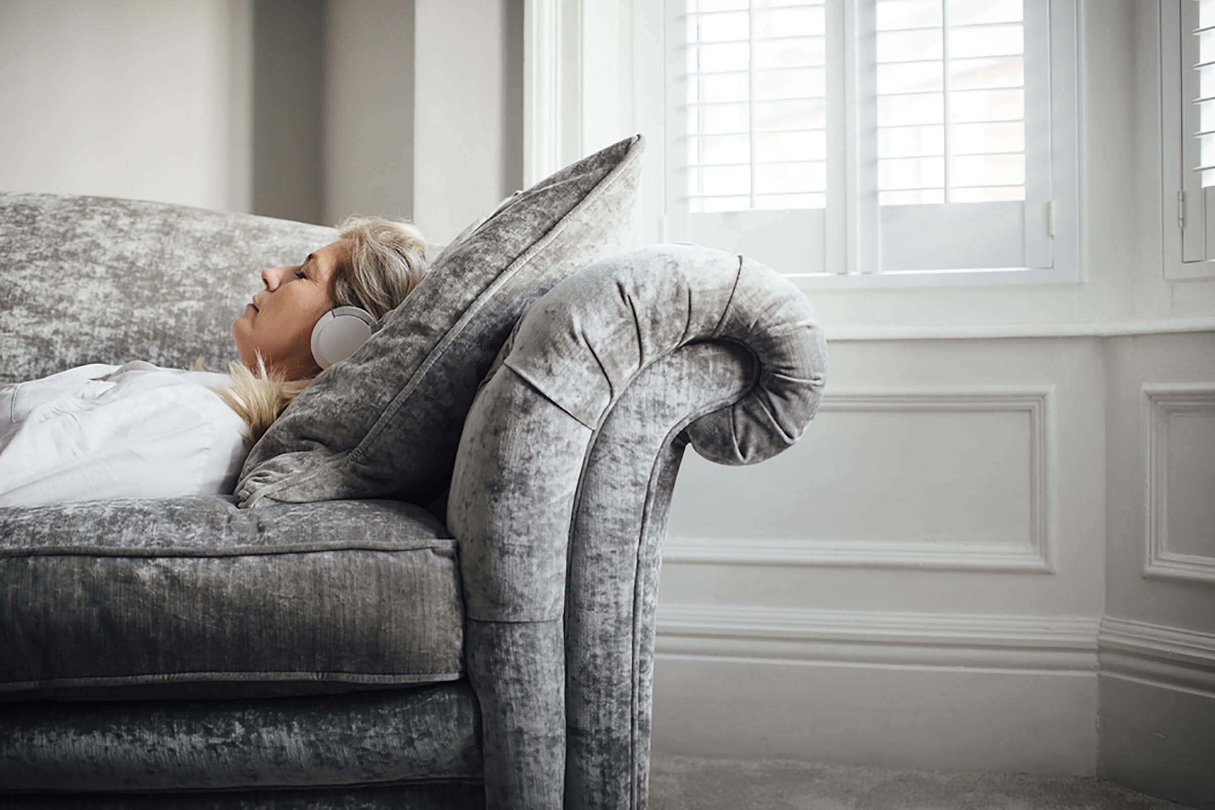 woman napping on couch with headphones