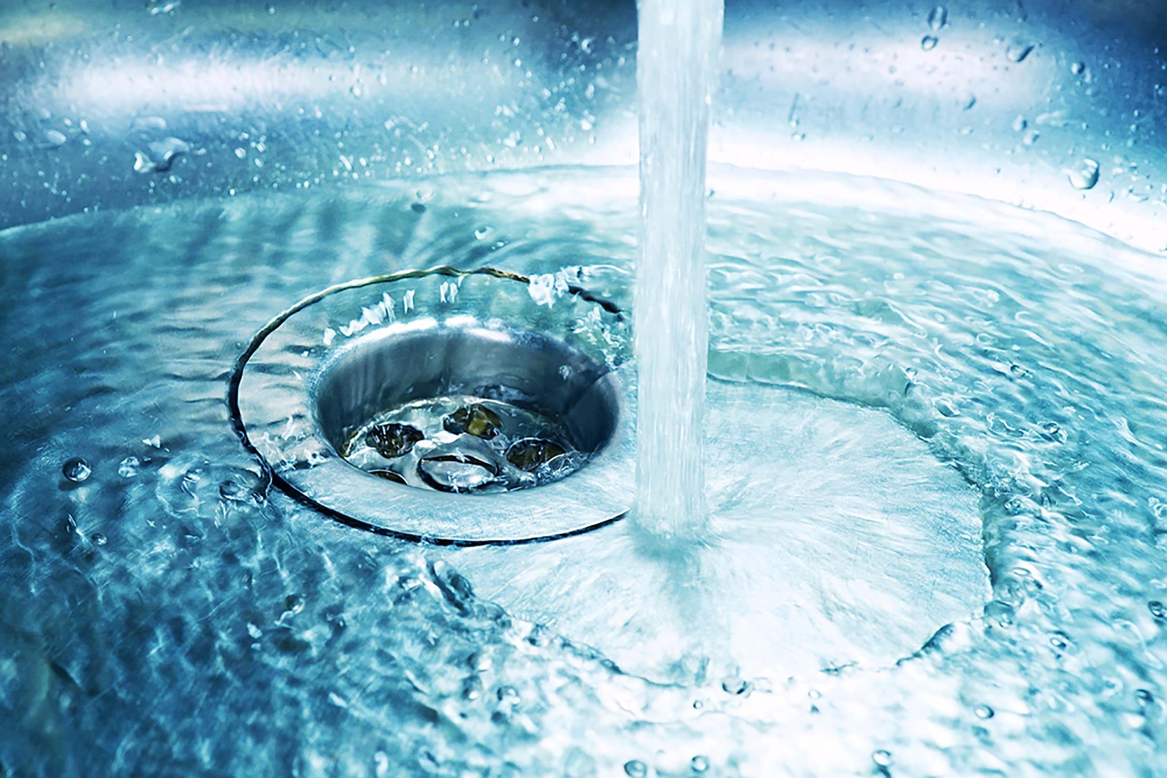 water from a faucet running down a sink drain