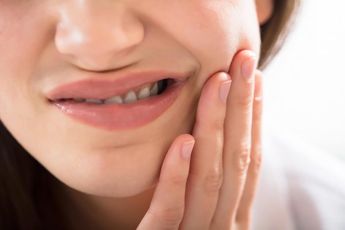 woman wincing and holding her jaw