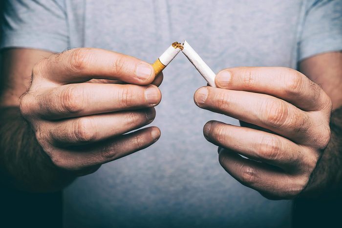 man snapping a cigarette in half