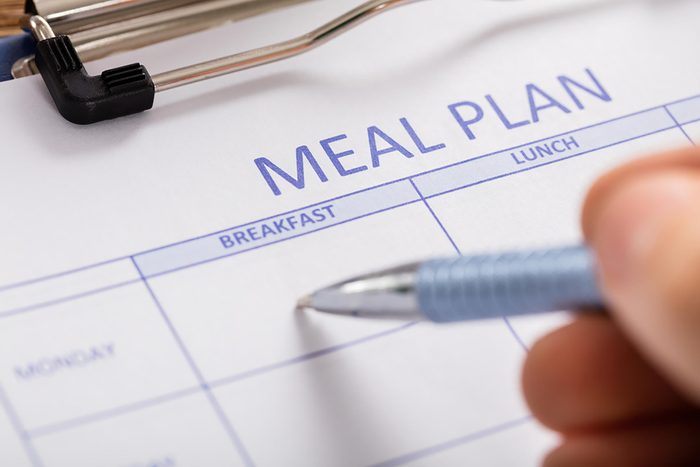 Someone filling in a day on a meal plan calendar