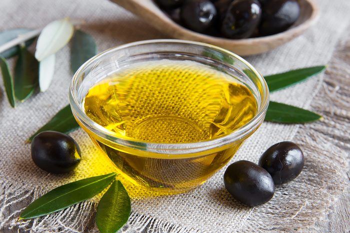 Olive-oil in a bowl with black olives on the side