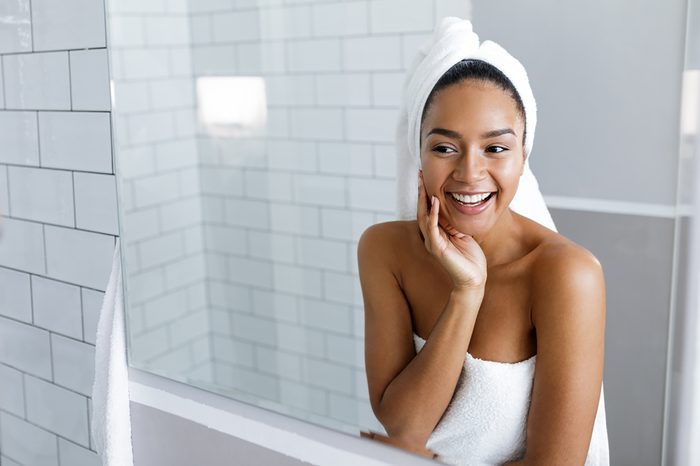 woman wearing a towel, looking in the mirror