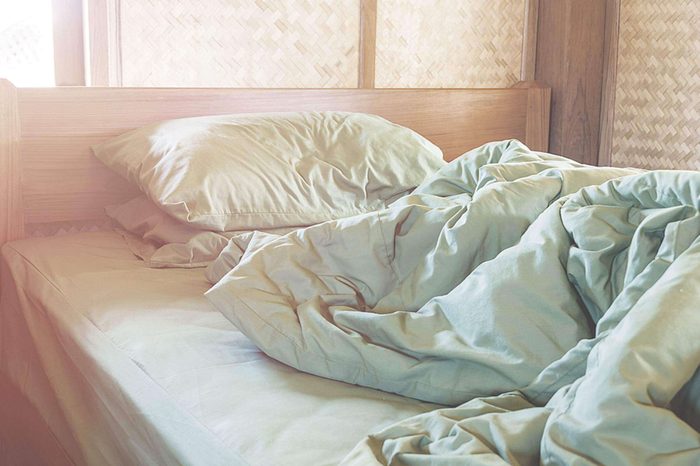 An empty, unmade bed.