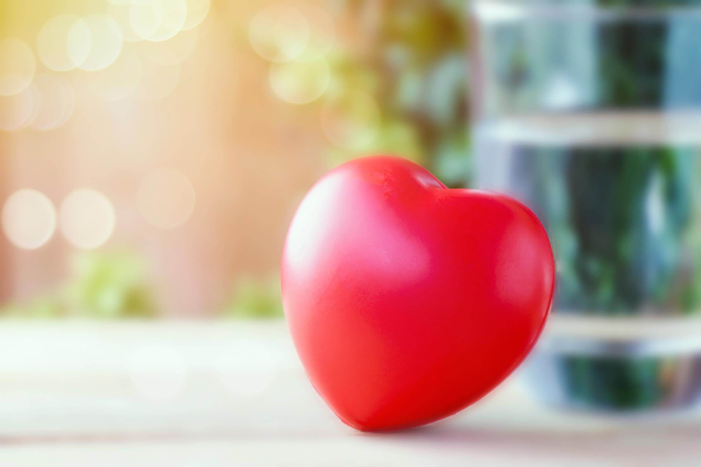 toy heart leaning against glass of water