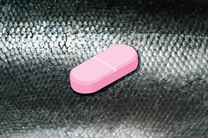 Illustration of a vitamin B12 caplet on a fish skin background.