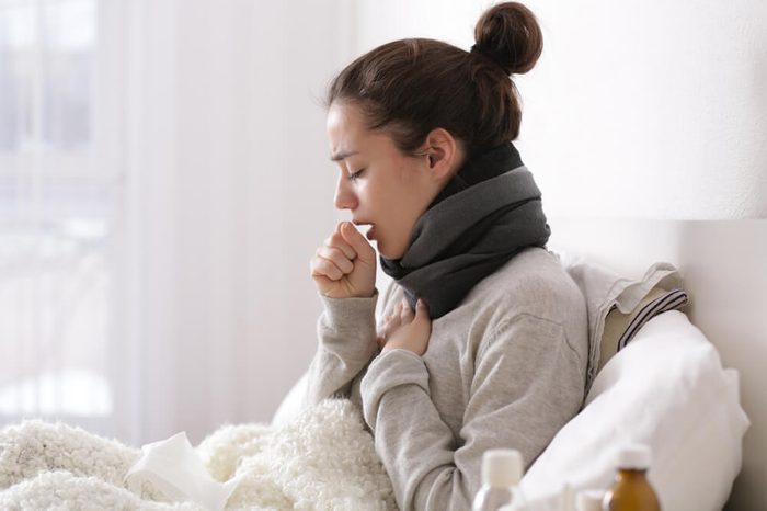 Young ill woman in bed at home.