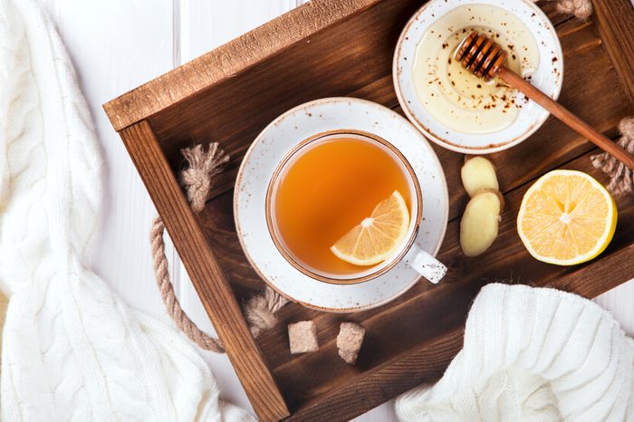 Cup of Ginger Tea with Lemon and Honey on a tray served in bed.