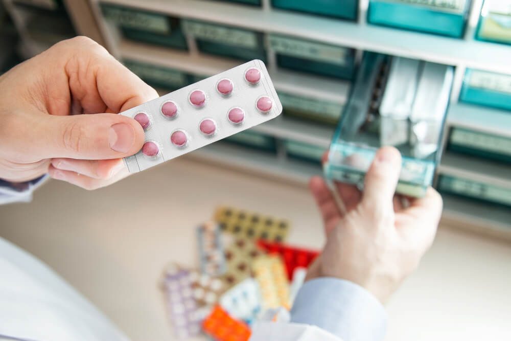 Closeup hands of pharmacist man choosing medicines at pharmacy. Drug store.Medical image. 