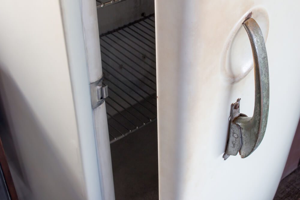 Old white vintage refrigerator door handle with copy space for text. Refrigerator handle concept.