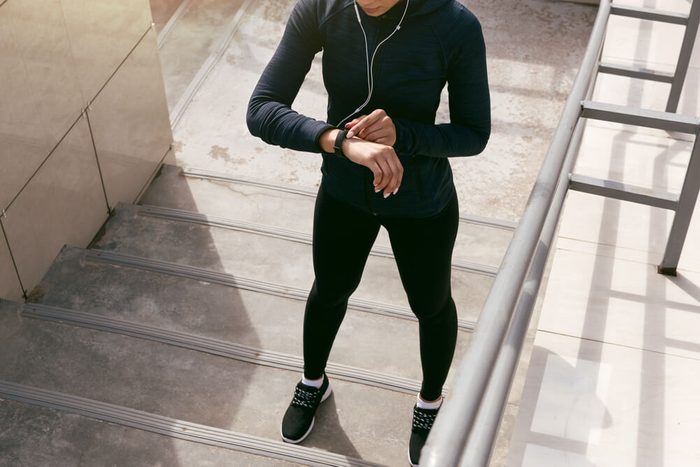 Young woman wearing sports clothing looking at activity tracker