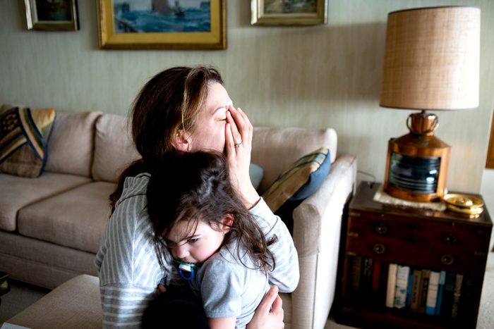 tired mother holding toddler