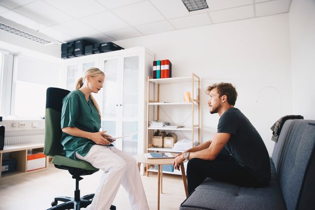 young man talking to female nurse at doctor's office