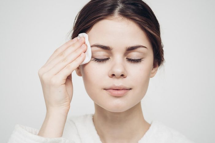 Woman swiping cleansing pad over her face