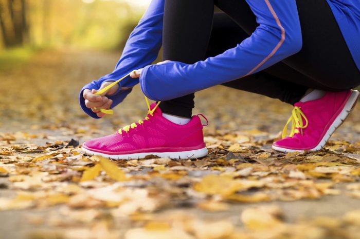 Woman lacing up running shoes