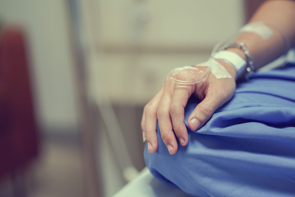 close up patient man hand with label and drip waiting for operation of chemotherapy medical , cancer day concept