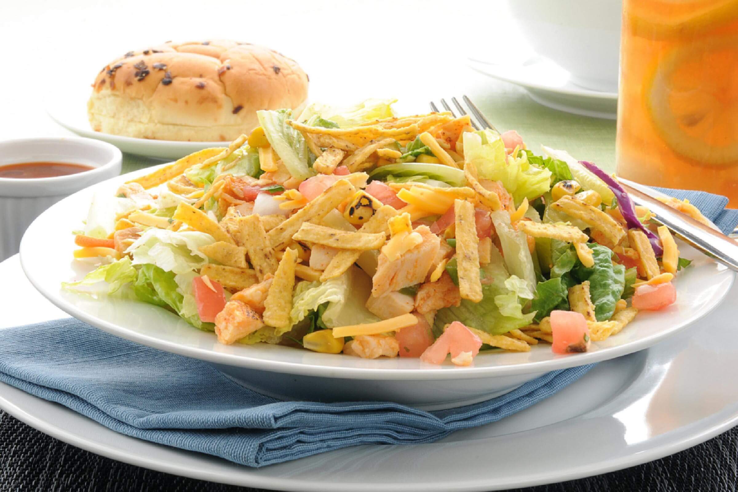 A taco salad with corn chip strips