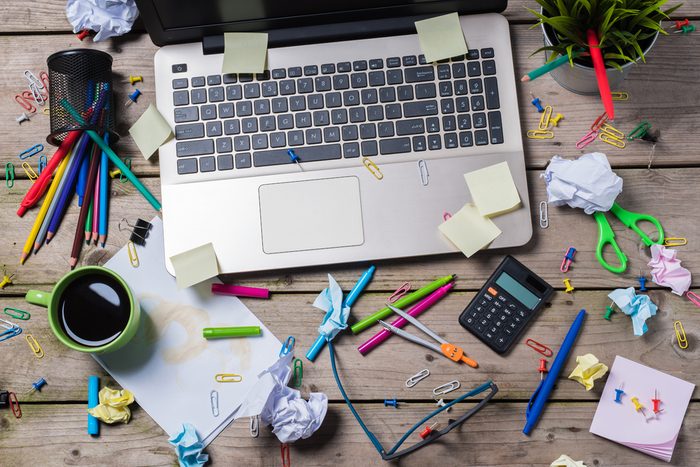 Messy office desk and laptopo