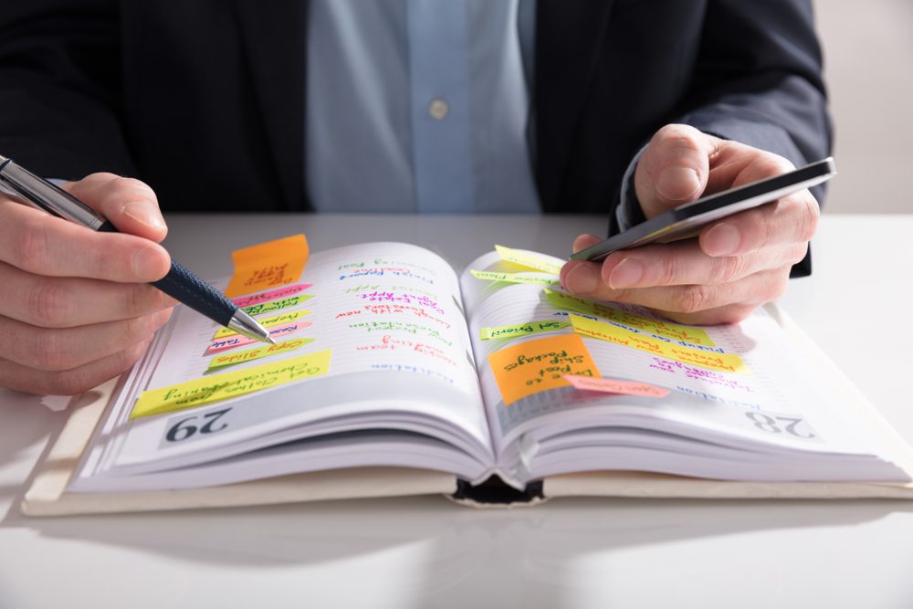 person writing in journal or diary