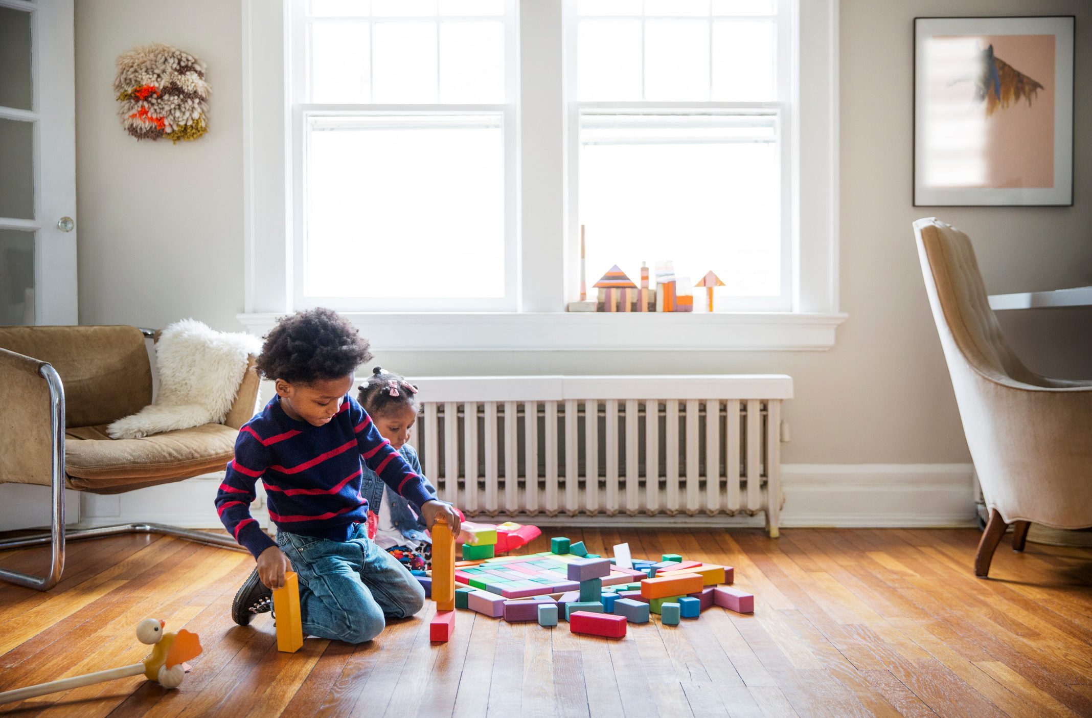 brother and sister playing with toys at home
