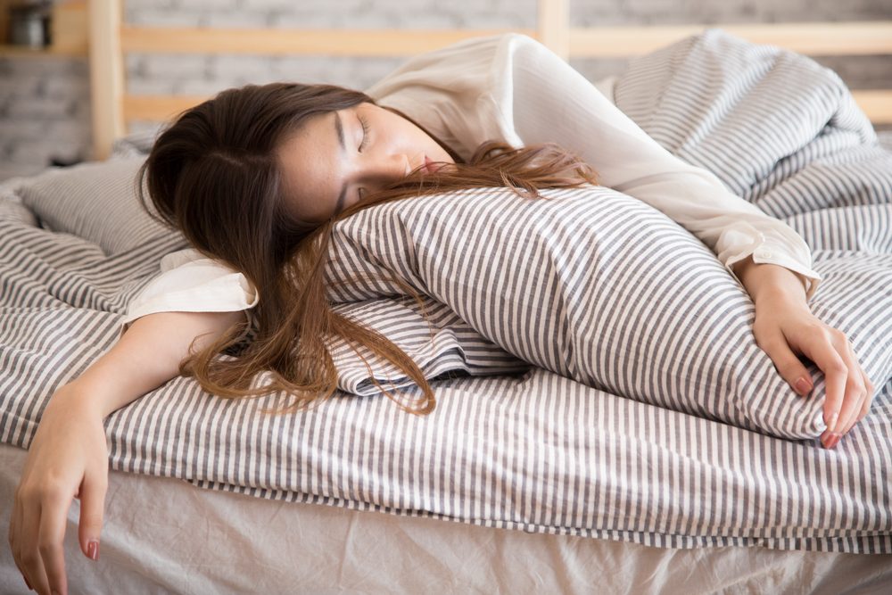 Beautiful lazy Asian woman sleeping on the bed at late morning