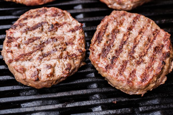 Preparing a batch of ground beef patties or frikadeller on grill or BBQ