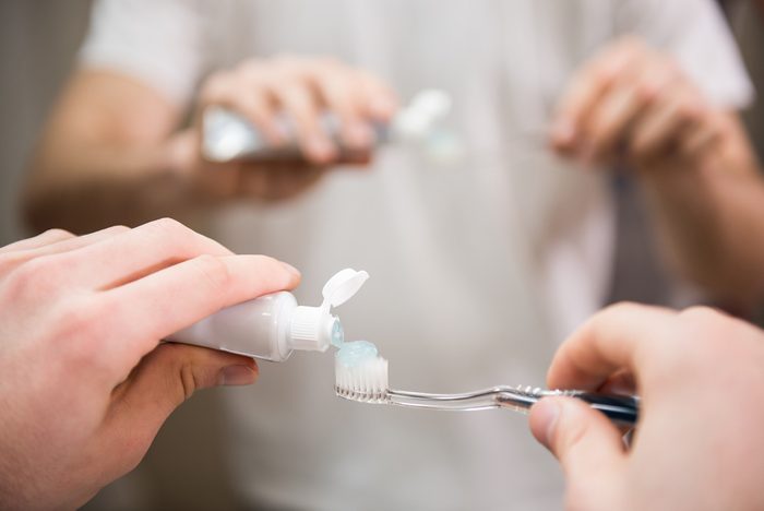 putting toothpaste on tootbrush