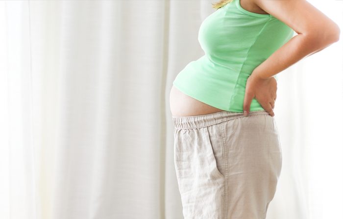 Pregnancy, motherhood- close up of happy pregnant woman indoors