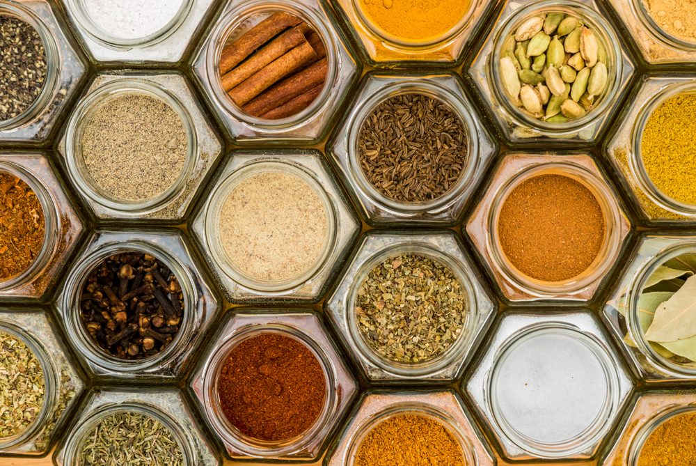 Colorful herbs and spices in hexagonal glass jars. Natural colors and top view. Horizontal picture.