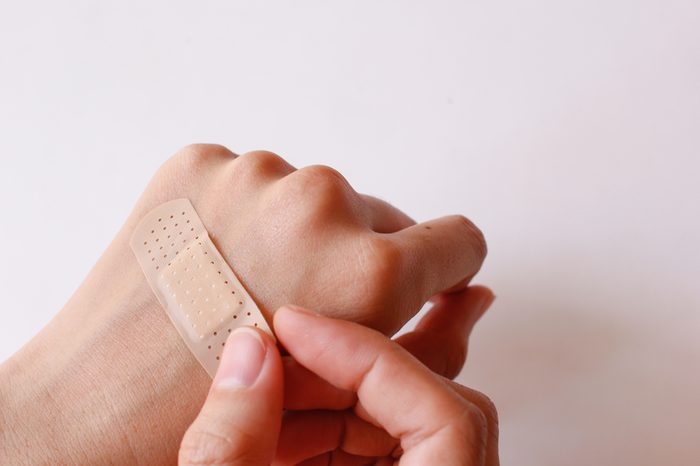 Hand with a bandage covering a cut.