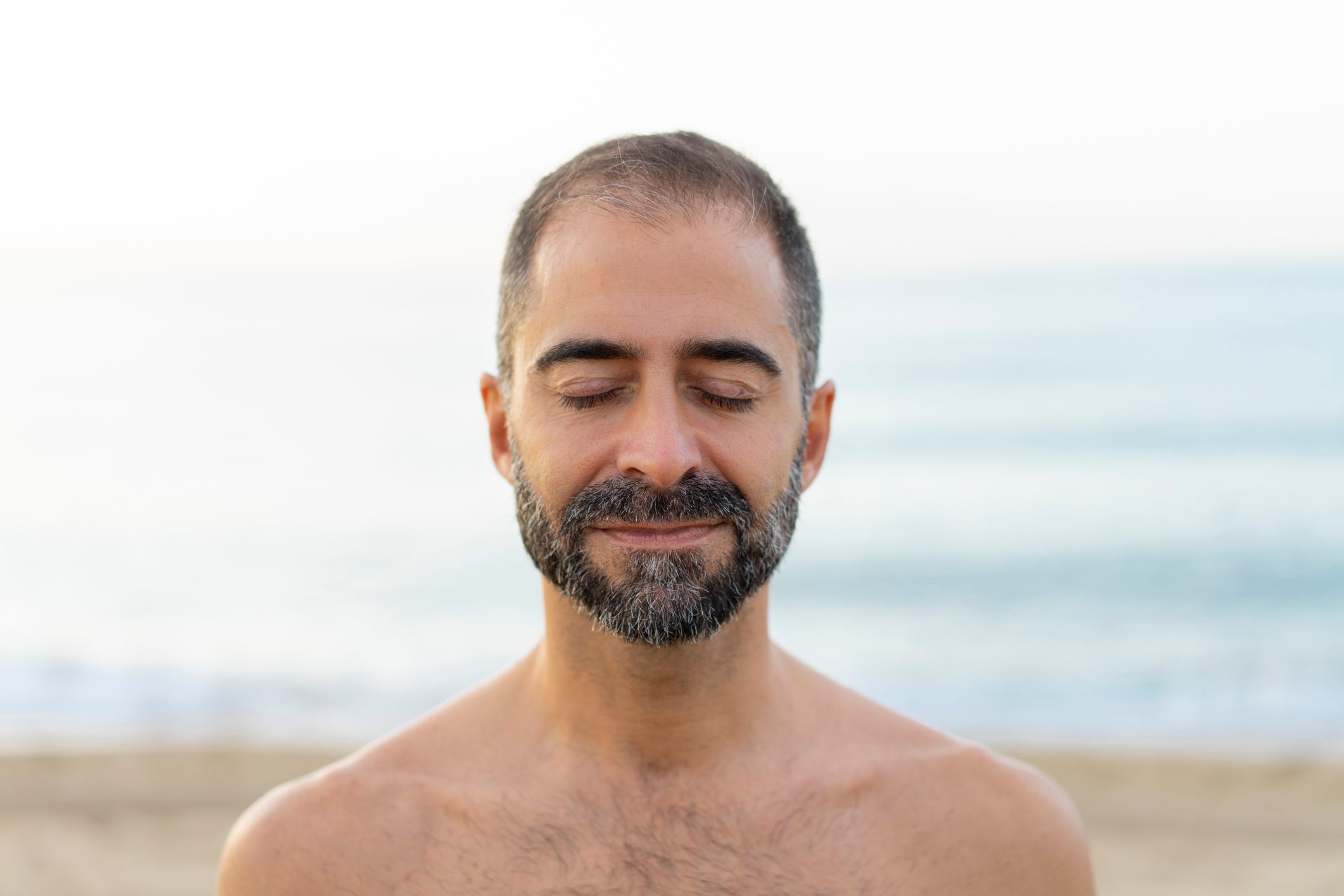 man meditating on the beach