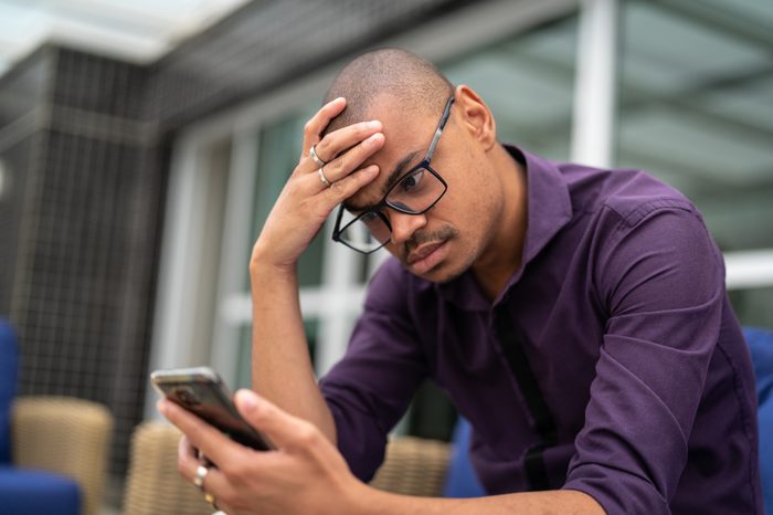 young man upset looking at his phone