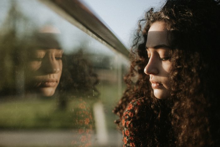 close up of young woman looking out window