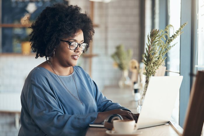 woman sitting in cafe using laptop computer