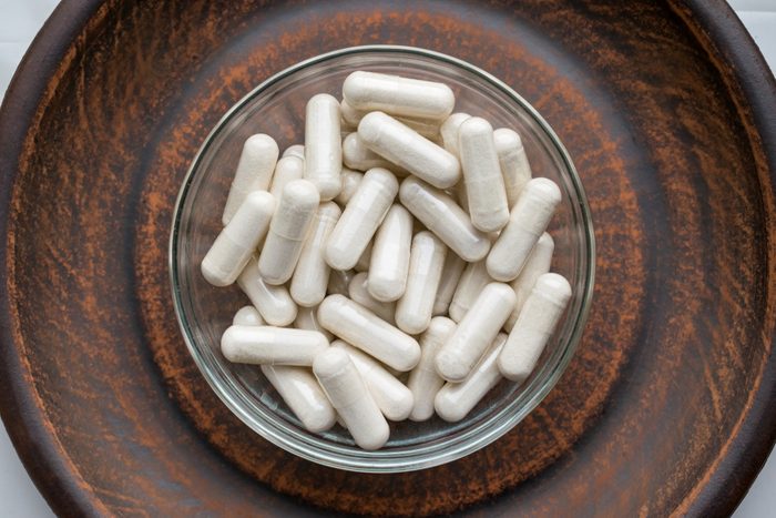 Kava Kava Extract root Veg Capsules on round clay brown plate. Herbal Supplements with calming Relaxation, effect, helps support emotional balance. Anti stress herbal pills Dietary Supplement