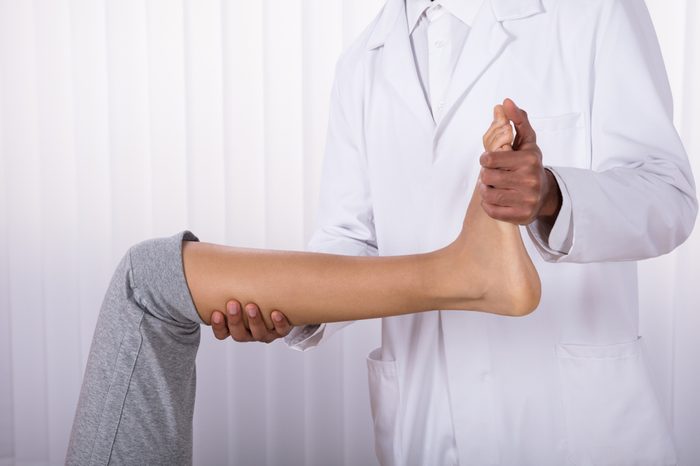 Woman doing leg and knee exercises with a doctor.